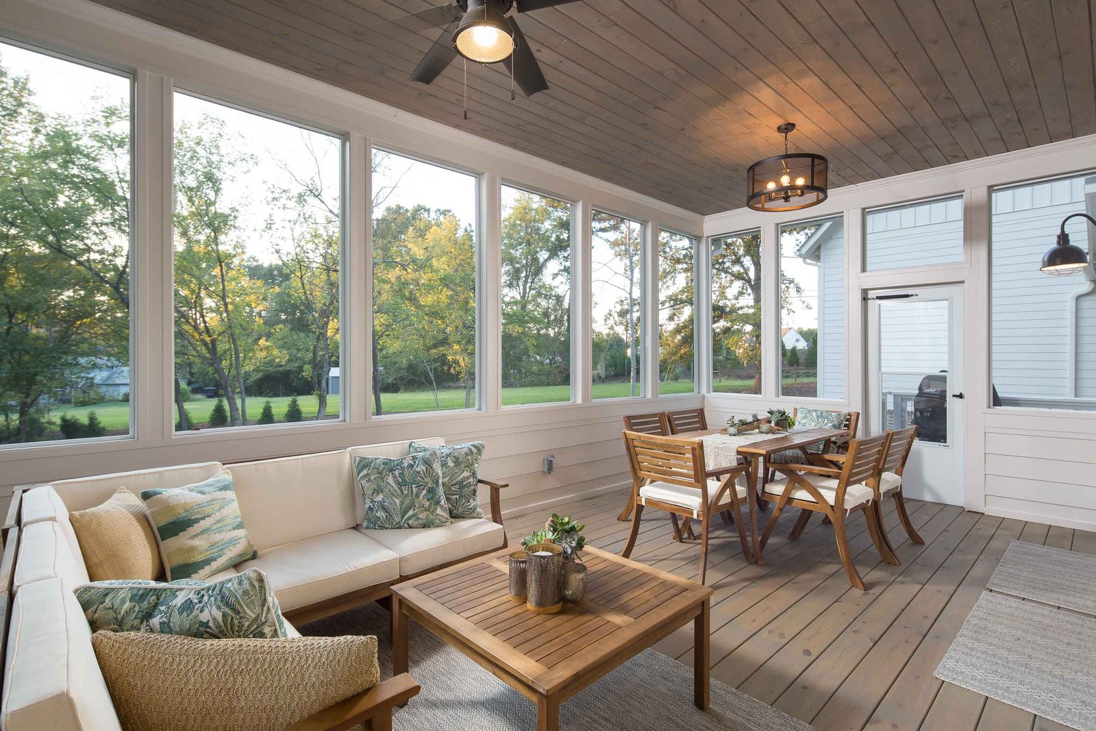 Screened porch with lounge seating and dining table — Austin Garner Rd, custom home built by Ironwood Construction Group