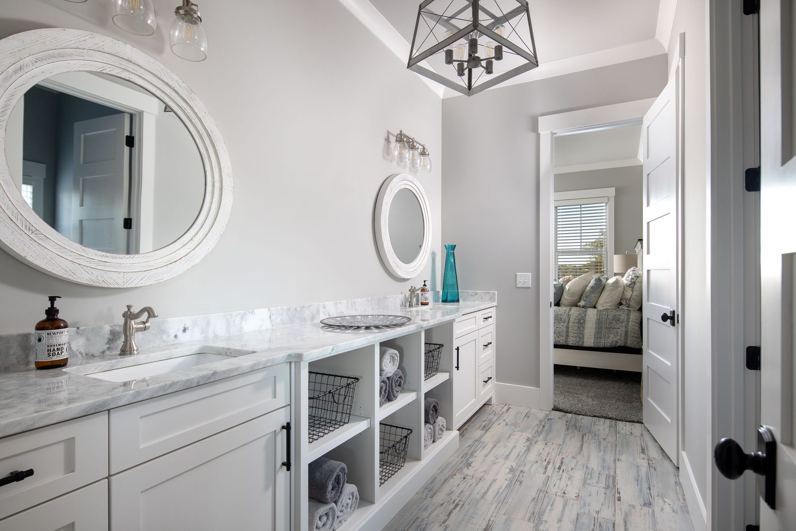 Hall bath vanity with round mirrors and open shelving — Glausier, custom home built by Ironwood Construction Group